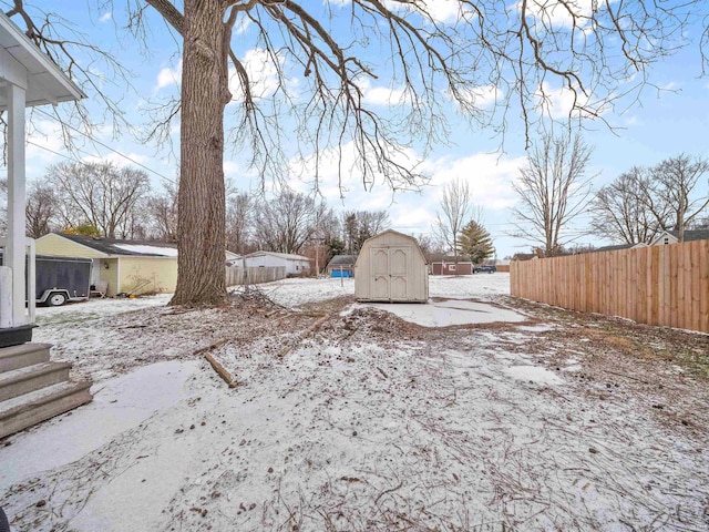 yard layered in snow featuring a storage unit