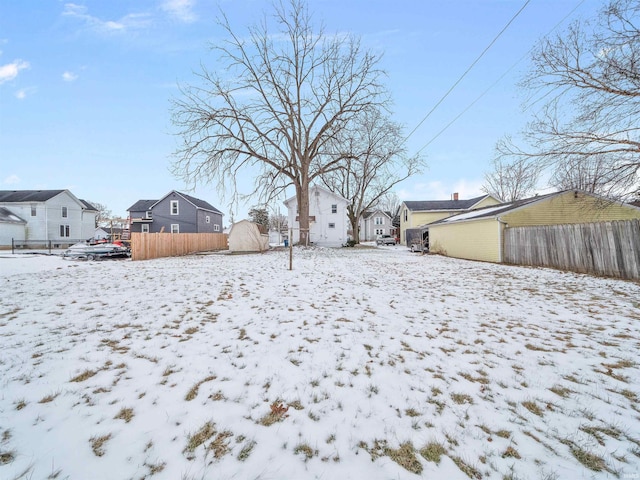 yard layered in snow with a storage shed