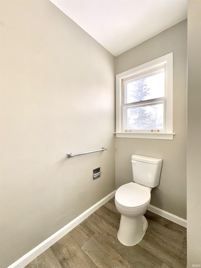 bathroom featuring toilet, baseboards, and wood finished floors