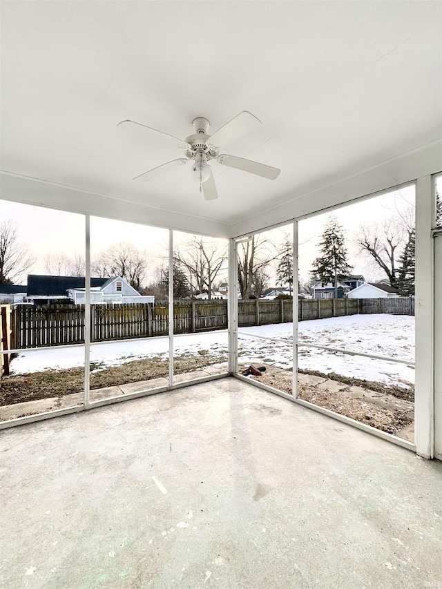 unfurnished sunroom featuring ceiling fan and a wealth of natural light