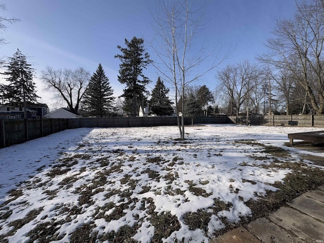 snowy yard featuring a fenced backyard