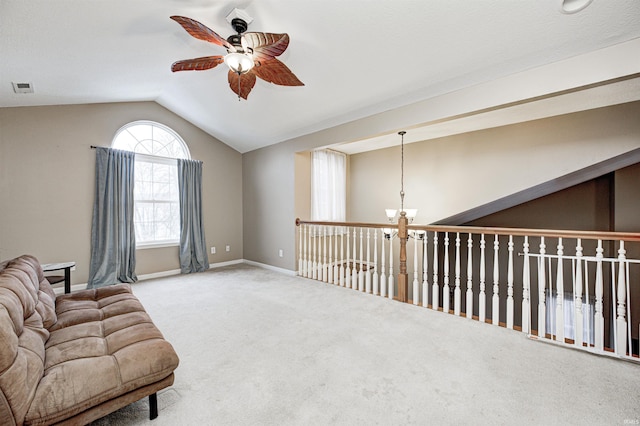 living area featuring ceiling fan with notable chandelier, vaulted ceiling, and light carpet