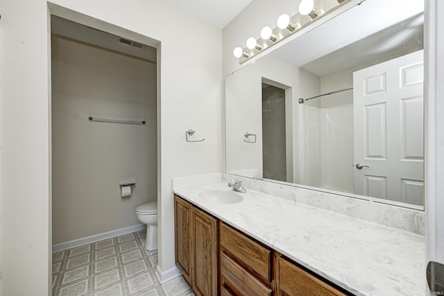 bathroom with vanity, a shower, and toilet