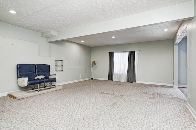 sitting room with a textured ceiling and carpet