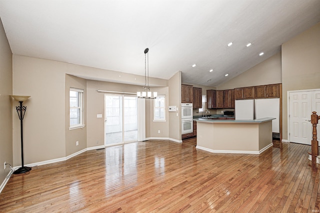 kitchen featuring a center island, hanging light fixtures, white double oven, a notable chandelier, and hardwood / wood-style flooring