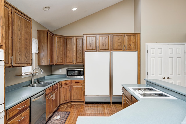 kitchen with sink, vaulted ceiling, light hardwood / wood-style floors, and appliances with stainless steel finishes