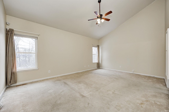 unfurnished room with high vaulted ceiling, plenty of natural light, light colored carpet, and ceiling fan