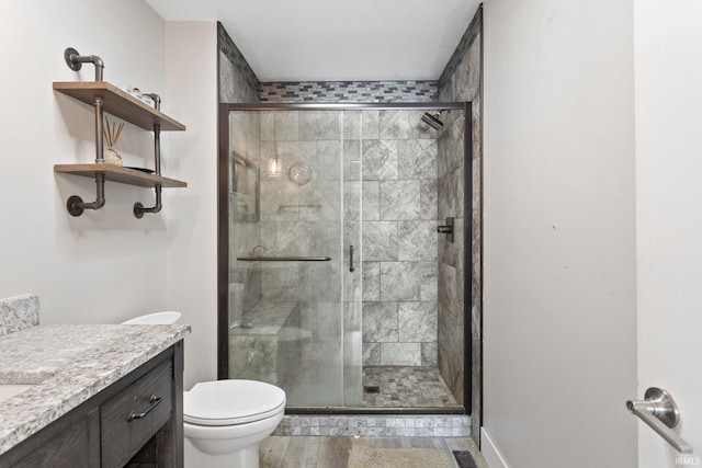 bathroom featuring an enclosed shower, vanity, and toilet