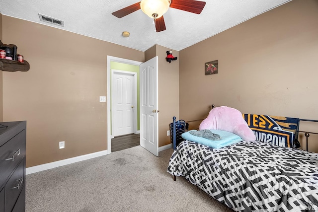 bedroom with light carpet, a textured ceiling, and ceiling fan