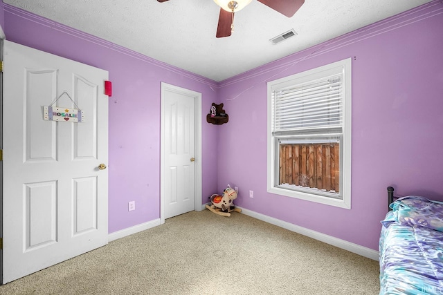 unfurnished bedroom featuring ceiling fan, carpet floors, and a textured ceiling