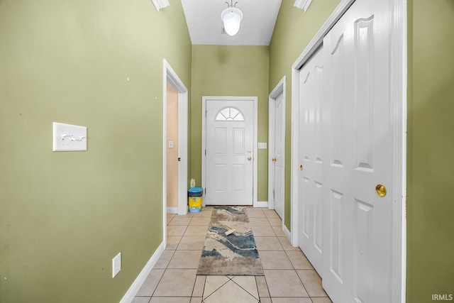 entryway with light tile patterned flooring and a high ceiling