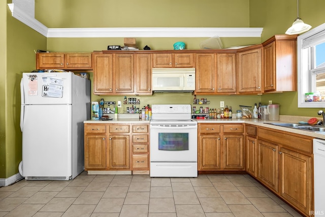 kitchen with sink, crown molding, white appliances, light tile patterned floors, and decorative light fixtures