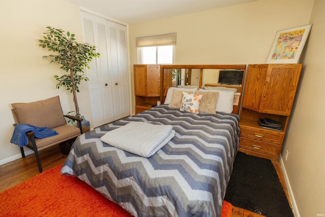 bedroom with dark wood-type flooring and a closet