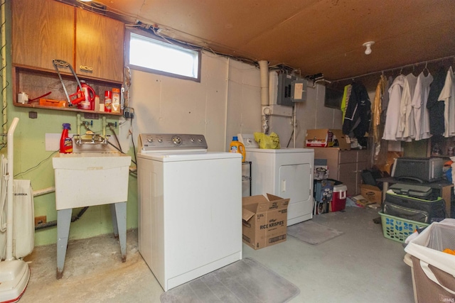 clothes washing area with electric panel, sink, and washer and dryer