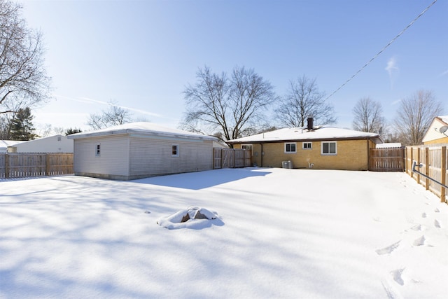 snow covered house featuring central AC