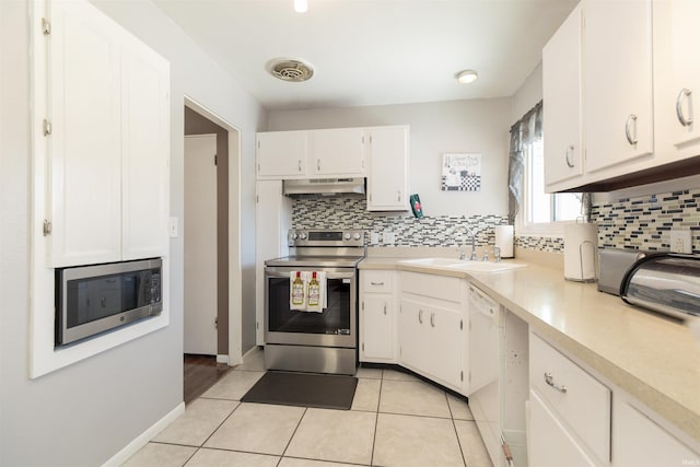 kitchen with appliances with stainless steel finishes, white cabinetry, sink, decorative backsplash, and light tile patterned floors