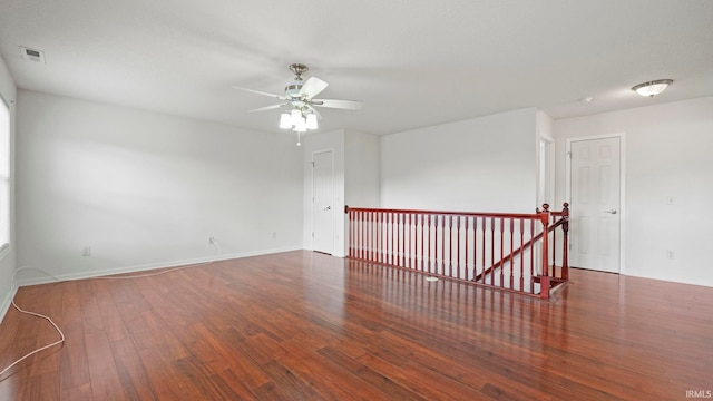 empty room featuring ceiling fan and dark hardwood / wood-style flooring