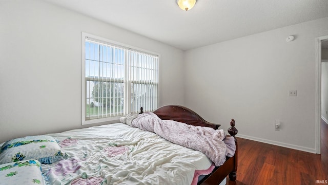 bedroom with dark wood-type flooring