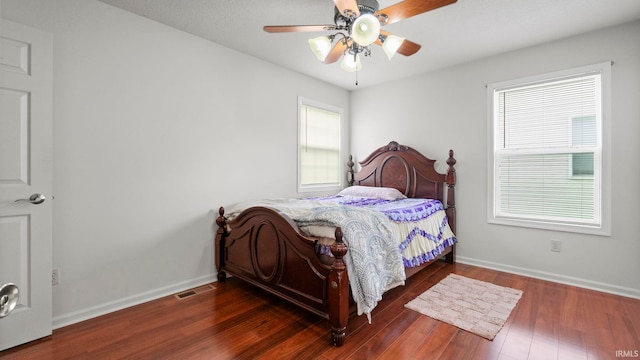 bedroom with ceiling fan and dark hardwood / wood-style floors