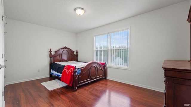 bedroom with dark hardwood / wood-style flooring