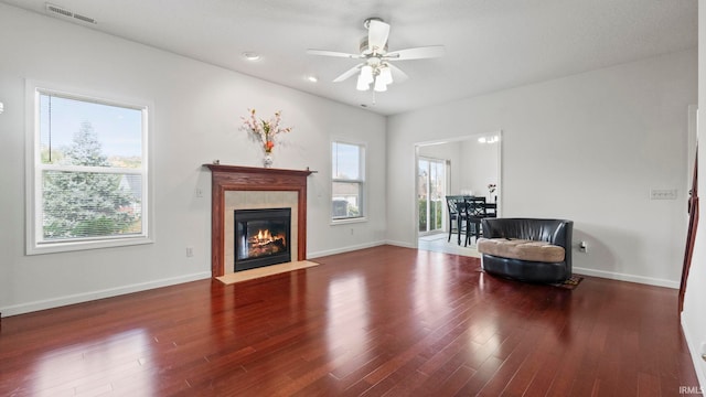 sitting room featuring ceiling fan, a tiled fireplace, and hardwood / wood-style floors