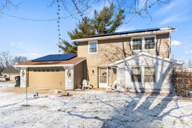 view of front facade featuring a garage and solar panels