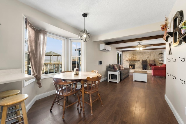 dining area with beam ceiling, a textured ceiling, an AC wall unit, dark hardwood / wood-style floors, and a fireplace