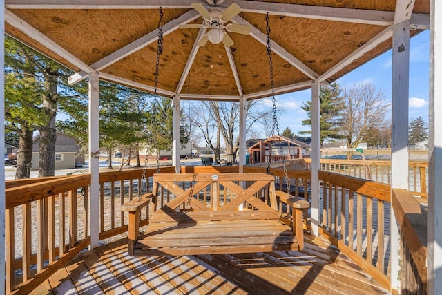 wooden terrace with a gazebo and ceiling fan