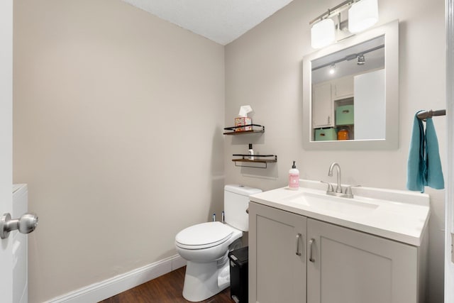 bathroom featuring vanity, toilet, and hardwood / wood-style floors