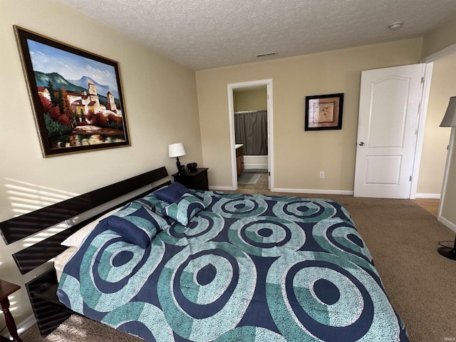 carpeted bedroom featuring ensuite bathroom and a textured ceiling