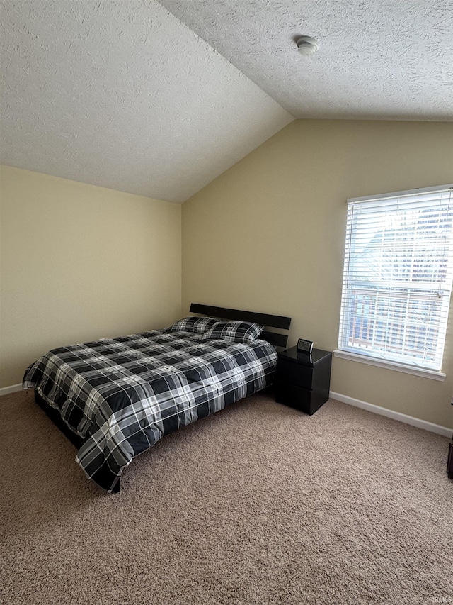 bedroom with lofted ceiling, a textured ceiling, and carpet flooring