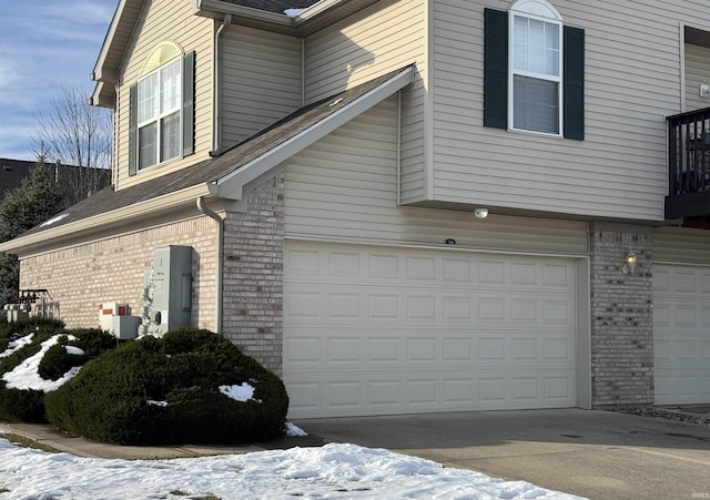 view of snowy exterior featuring a garage