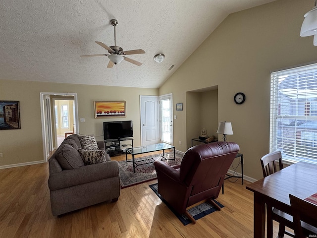 living room featuring ceiling fan, a healthy amount of sunlight, light hardwood / wood-style floors, and a textured ceiling