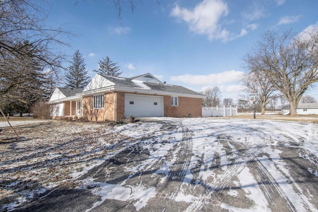 snow covered property with a garage