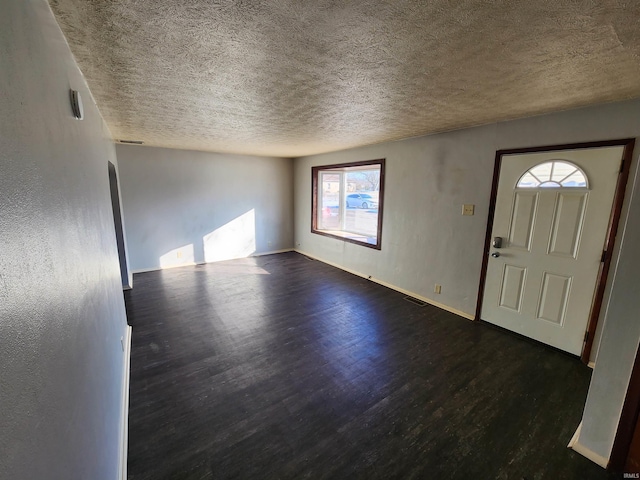 entryway featuring dark wood-type flooring and a textured ceiling