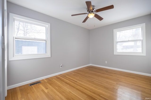 empty room with ceiling fan, a healthy amount of sunlight, and light wood-type flooring