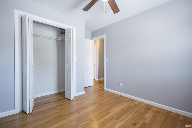 unfurnished bedroom featuring ceiling fan, a closet, and light hardwood / wood-style flooring