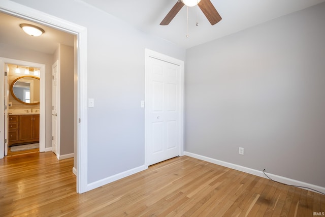 unfurnished bedroom featuring ceiling fan, sink, and light wood-type flooring