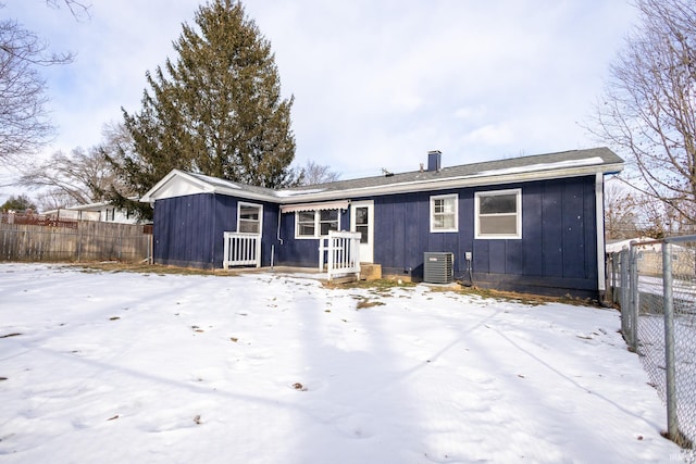 snow covered back of property with central air condition unit