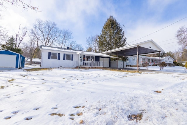 view of front of house featuring a porch and a storage shed