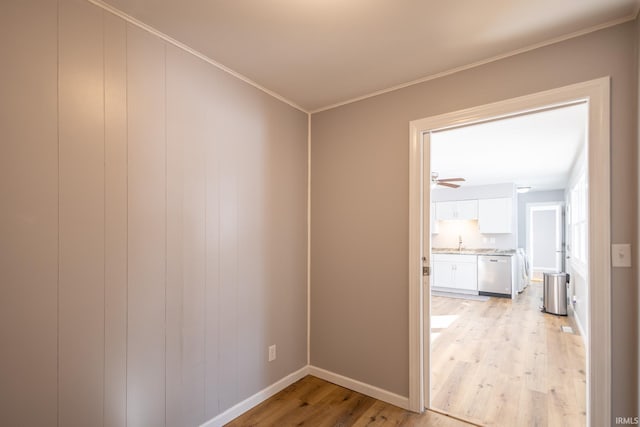 corridor with sink, ornamental molding, and light hardwood / wood-style floors