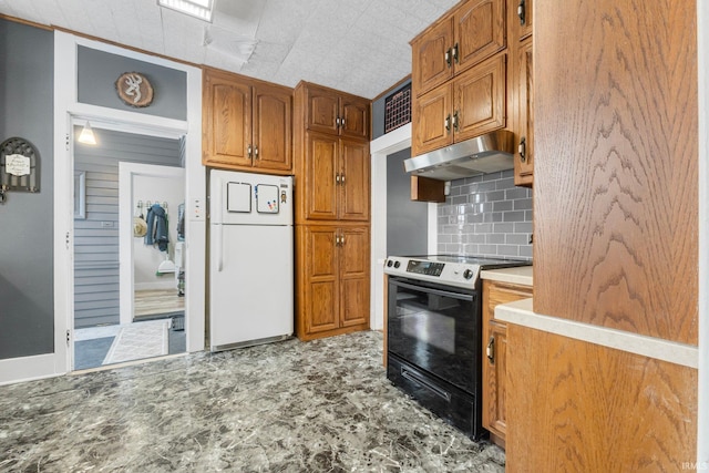 kitchen featuring electric stove, white fridge, and backsplash