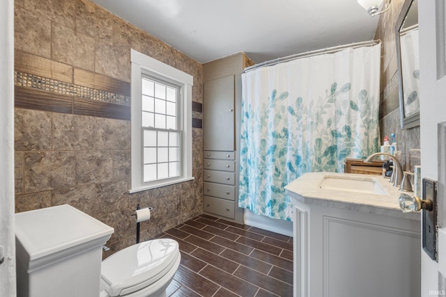 bathroom featuring a shower with curtain, vanity, toilet, and tile walls