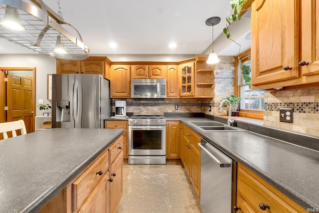 kitchen featuring tasteful backsplash, appliances with stainless steel finishes, sink, and pendant lighting