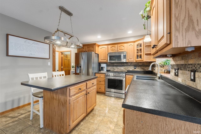 kitchen with sink, decorative light fixtures, a center island, a kitchen breakfast bar, and stainless steel appliances