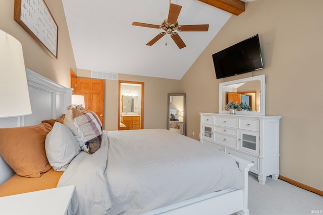 carpeted bedroom featuring ensuite bath, lofted ceiling with beams, and ceiling fan