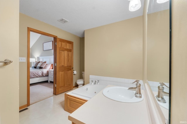 bathroom with a tub to relax in, toilet, and sink