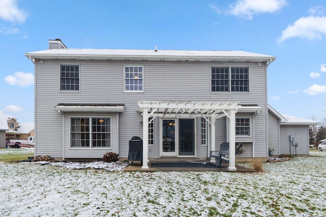 snow covered property with a pergola and a patio area