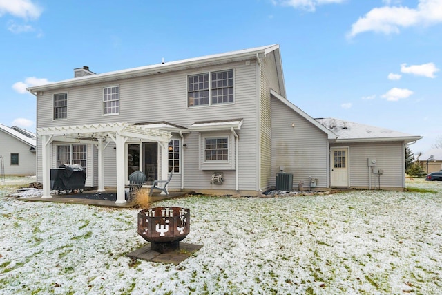 snow covered rear of property with a pergola, a fire pit, and central air condition unit