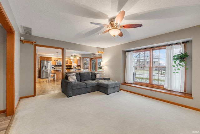 carpeted living room featuring a textured ceiling and ceiling fan